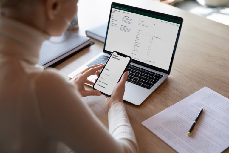 Index Exchange UI displayed on a cell phone and laptop screen with a person sitting in front of each at a desk.
